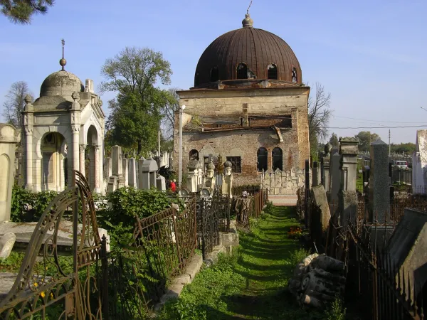 A peaceful Jewish cemetery with rows of weathered headstones — reflecting the Jewish tradition of simple, permanent burial