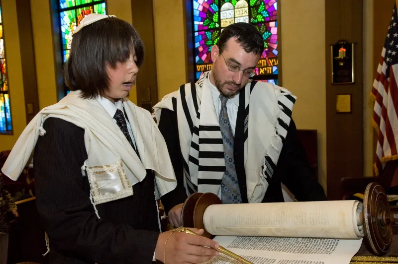 A young boy reading from the Torah during his Bar Mitzvah ceremony