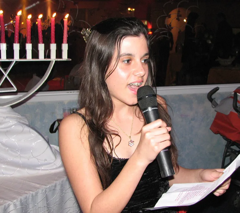 A young woman reading from the Torah at her bat mitzvah ceremony