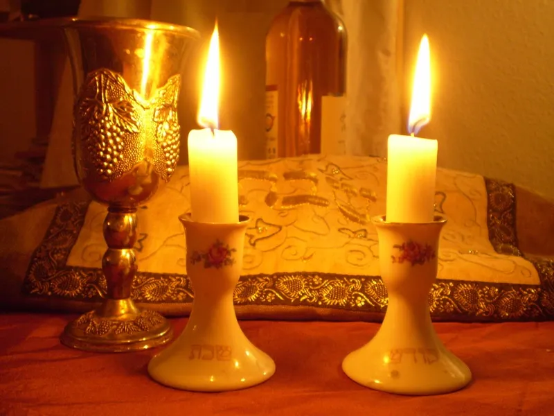 Shabbat candles glowing warmly, lit with the traditional blessing