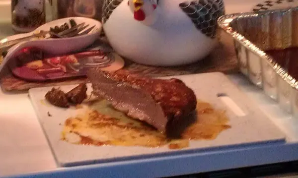 Raw brisket being seasoned before going into the oven