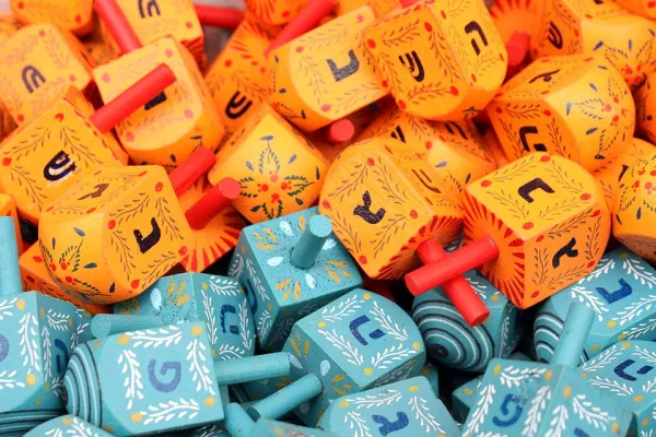 Children playing dreidel during a Hanukkah celebration with chocolate gelt