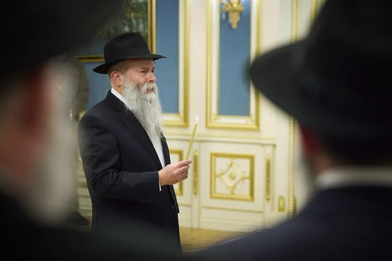 A lit menorah and a Christmas tree side by side in a December scene