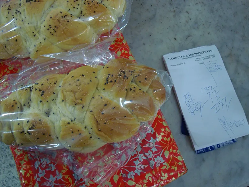 An assortment of Jewish desserts including rugelach, babka, and hamantaschen on a decorated table