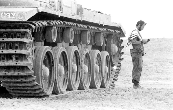 A Jewish man wearing tallit and tefillin during morning shacharit prayer