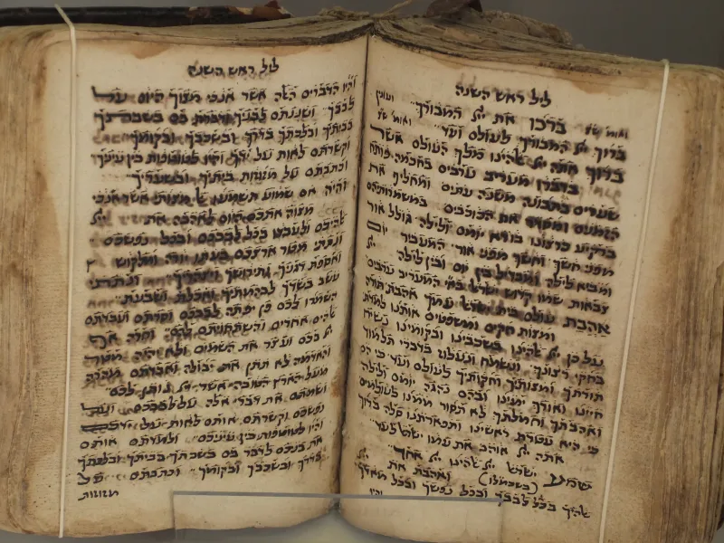 A peaceful bedroom with a prayer book on the nightstand