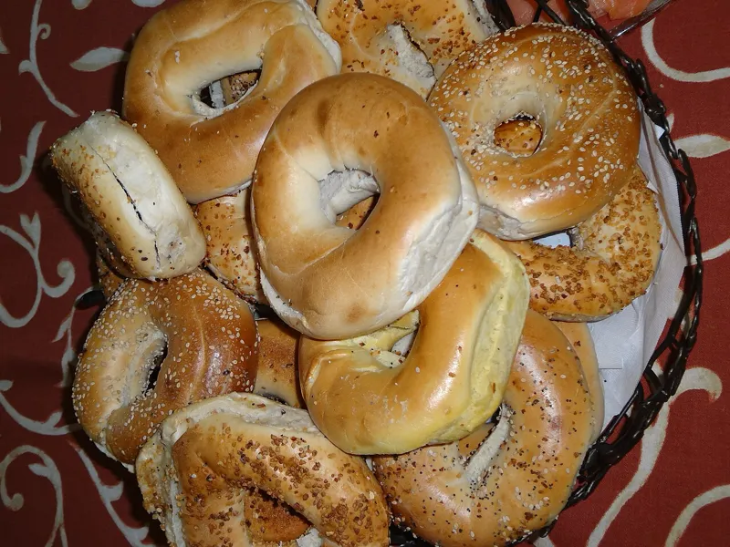 A smartphone displaying Hebrew text next to a traditional Torah scroll, symbolizing the intersection of technology and tradition