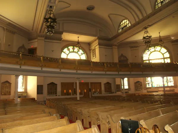 The interior of a historic synagogue with ornate architecture and the Torah ark
