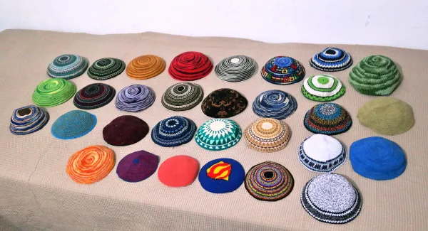 A collection of colorful knitted and crocheted kippot in various patterns and styles
