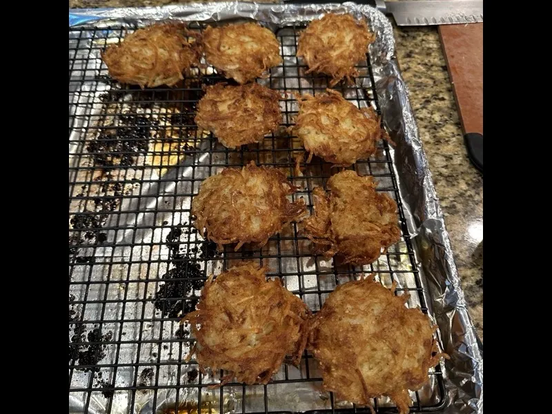 Golden crispy latkes on a plate with sour cream and applesauce