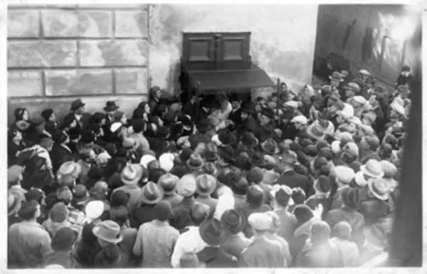 A joyful Hasidic farbrengen gathering with men singing and raising glasses