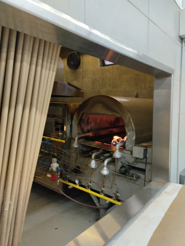 Workers in a matzah bakery rolling dough at high speed