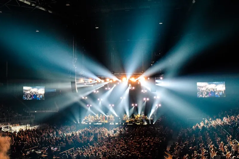 Paul Simon performing on stage with acoustic guitar