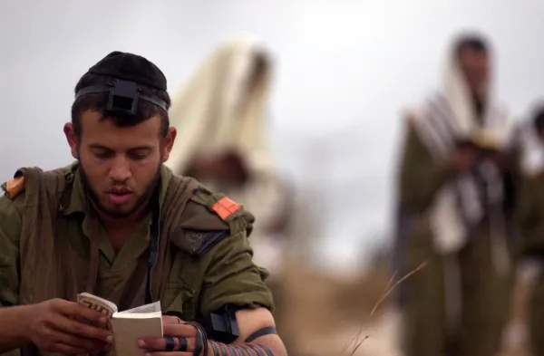 A Jewish man wearing tefillin during morning prayers