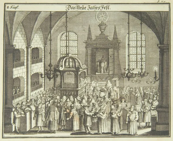 Apples, honey, pomegranates, and a round challah arranged on a Rosh Hashanah holiday table