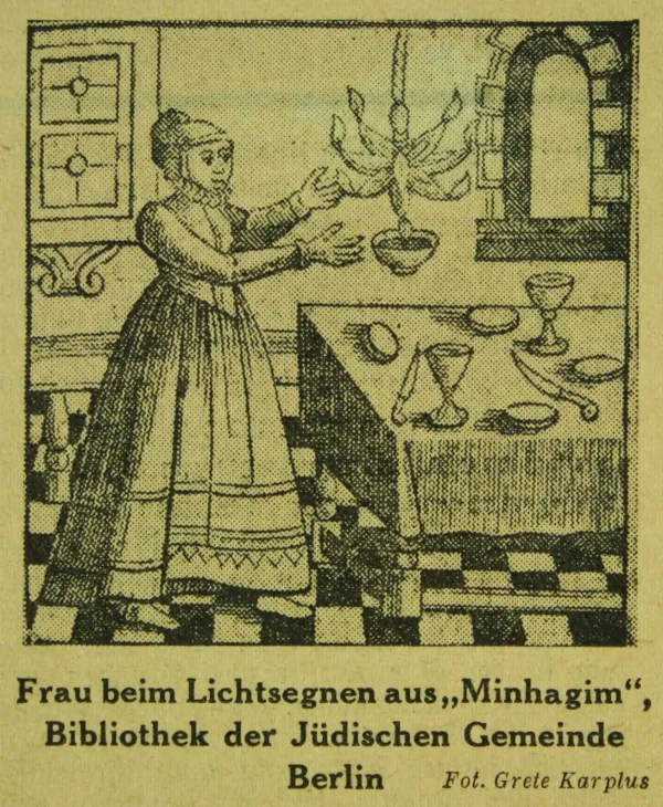 Two lit Shabbat candles in silver candlesticks