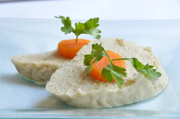 Homemade gefilte fish topped with slices of carrot, a classic Ashkenazi Shabbat dish