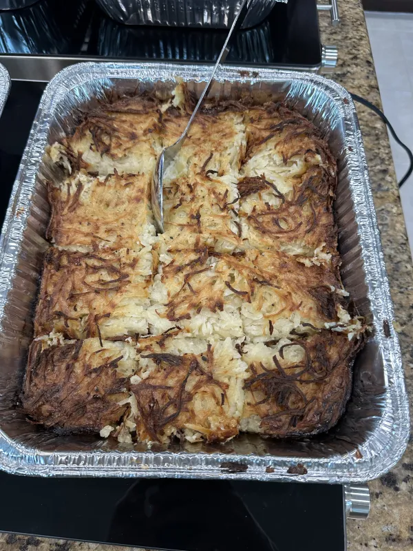 A tray of golden-brown potato kugel, a traditional Jewish baked side dish