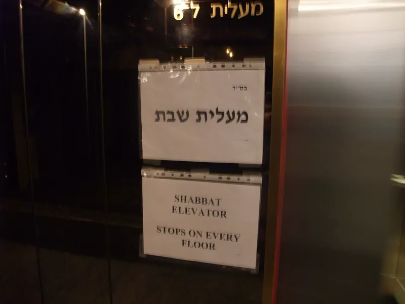 Smartphone placed face-down next to lit Shabbat candles, symbolizing digital rest