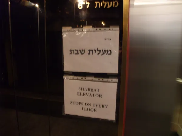 Family gathered around a Shabbat dinner table with phones put away, candles lit