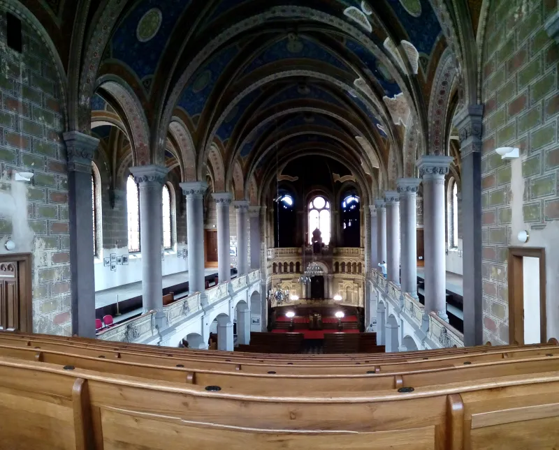 The ornate interior of a synagogue showing the ark and bimah