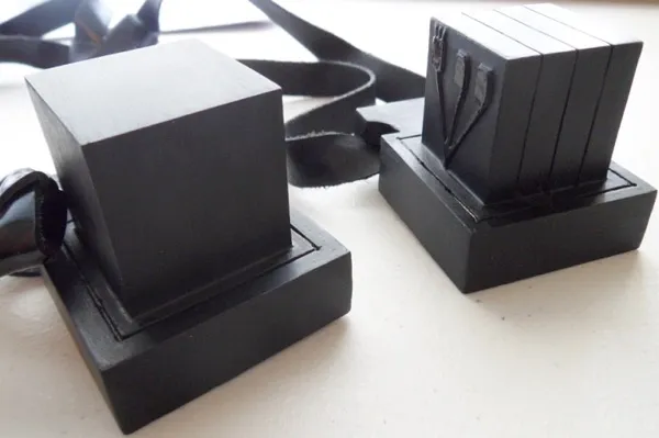 A complete set of tefillin showing the two black leather boxes (batim) and their straps (retzuot)
