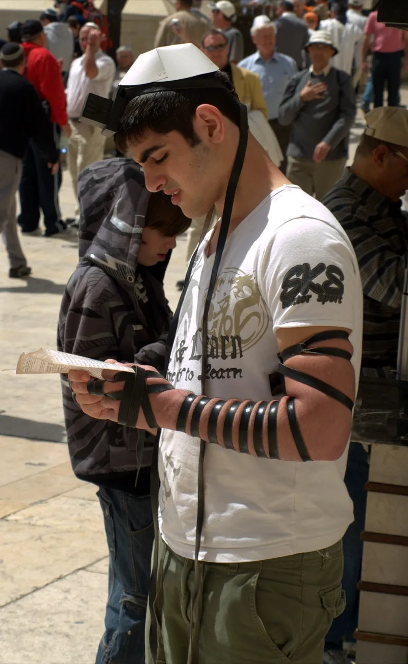 A Jewish man wearing tefillin during morning prayer