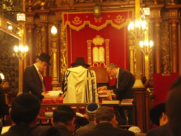 A cantor leading prayers from the bimah in a synagogue