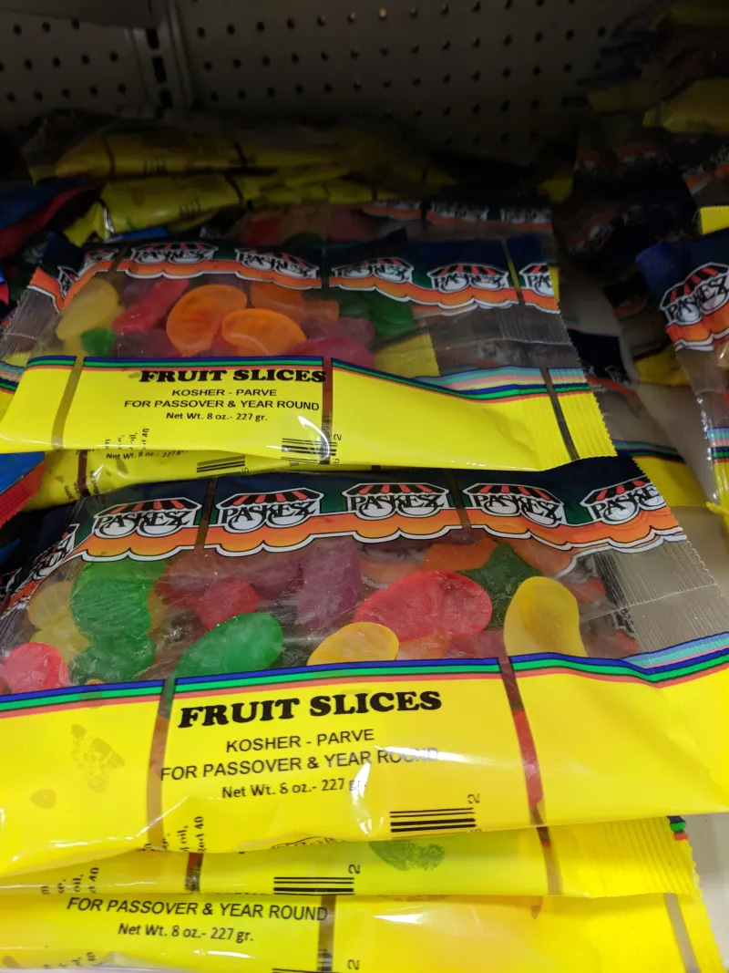 Interior of a kosher grocery store with neatly organized shelves of certified kosher products