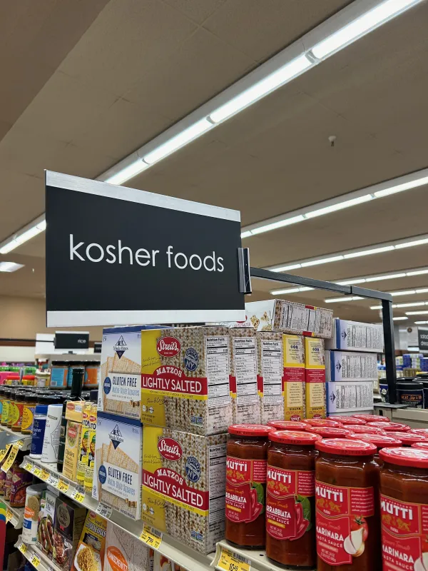 A kosher foods sign in a grocery store aisle indicating the kosher section